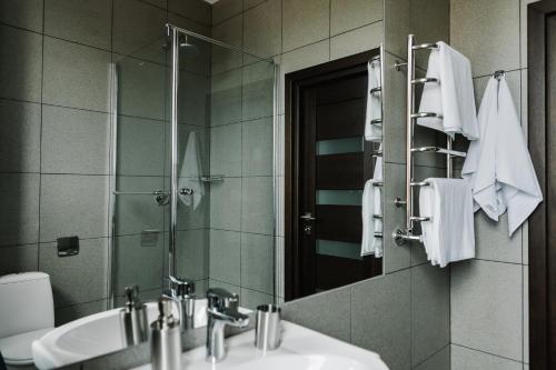 a bathroom with a sink and a mirror and towels at Готельно-рестораний комплекс Silver in Ivano-Frankivsʼk