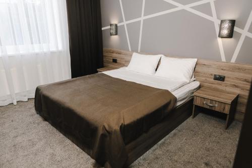 a bedroom with a large bed with a wooden headboard at Готельно-рестораний комплекс Silver in Ivano-Frankivsʼk
