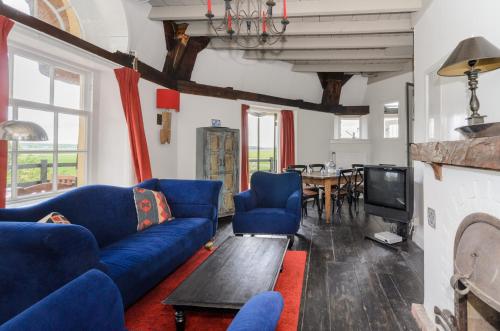 sala de estar con sofás azules y TV en Mondriaanmolen, a real Windmill close to Amsterdam, en Abcoude