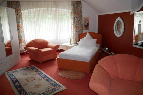 - une chambre avec un lit, une chaise et un canapé dans l'établissement Wohlfühlhotel Saxonia, à Bad Kissingen