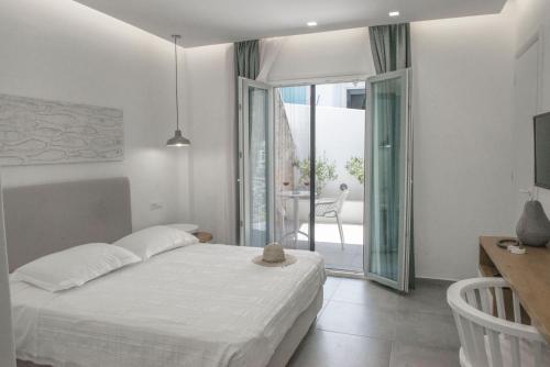 a white bedroom with a bed and a balcony at Casabella in Naxos Chora