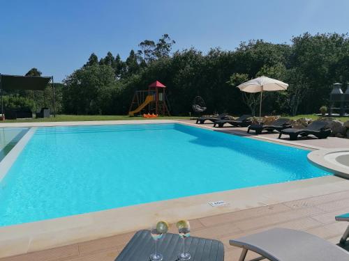 a swimming pool with chairs and a playground at PÉROLA d'ÓBIDOS T3 in Gaieiras