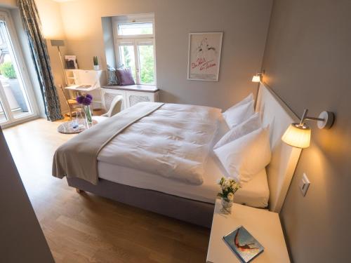 a bedroom with a bed and a table with a lamp at Romantik Hotel Schweizerhof & Spa Flims in Flims