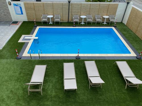 uma vista sobre uma piscina com espreguiçadeiras em Saint George Hotel em Asprovalta