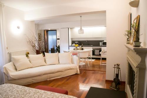 salon z białą kanapą i kuchnią w obiekcie Casetta dei Fichi - Parcheggio Gratuito w mieście Matera