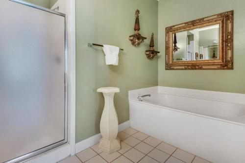 a bathroom with a bath tub and a mirror at TOPS'L Tides I in Destin