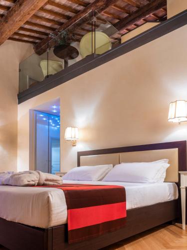 a bedroom with a large bed with white sheets at Parco Termale di Villa Dei Cedri in Lazise