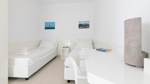 a white room with two beds and a couch at Rivazzurra Homes - A in Termoli