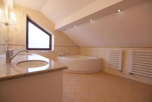 a bathroom with a sink and a bath tub at Dom przy lini brzegowej Jezioraka in Iława