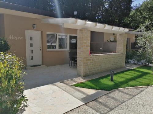 a backyard of a house with a patio at Holiday Park Mimoza in Bašanija