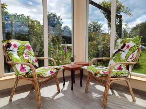 two chairs and a table in a room with windows at Ferienhaus Eifelrose in Simmerath
