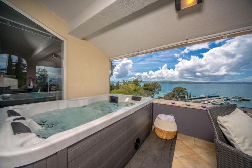 a large bath tub in a room with a large window at Apartments Sax in Crikvenica