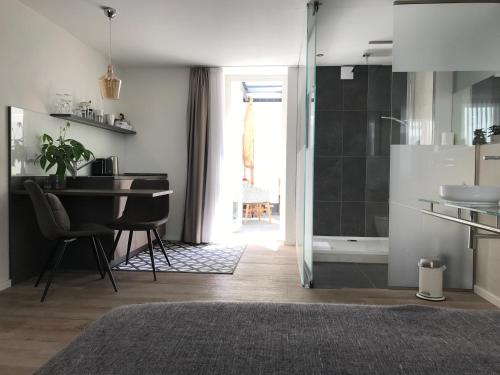 a bathroom with a sink and a table and a shower at SYBILLE KUNTZ Weingut Gästehaus in Lieser