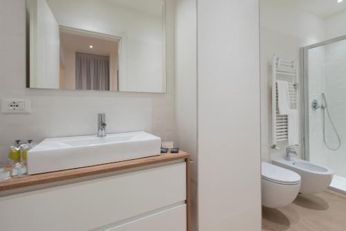 a white bathroom with a sink and a toilet at Milan Royal Suites - Centro in Milan