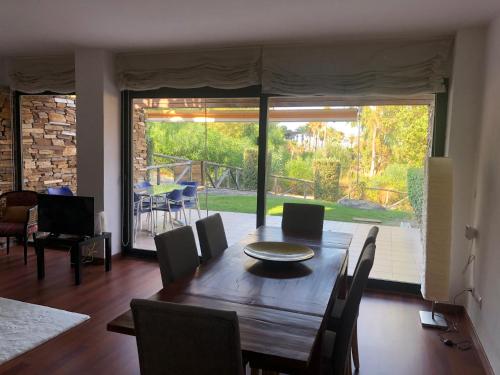 a dining room with a wooden table and chairs at Preciosa Casa de diseño Valle del Este Golf Resort ideal para familias in Vera