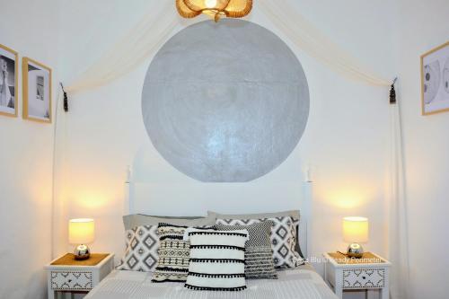 a bedroom with a bed with pillows and a large orb at Casa Blu, Beach Boho Chic, Beach and Pool - Fast Wifi in Porches