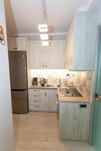a kitchen with white cabinets and a stainless steel refrigerator at Leonidas House in Parga