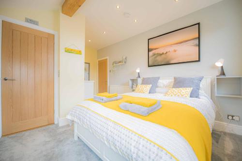 a bedroom with a large bed with yellow and blue pillows at Nesscliffe in Llangollen