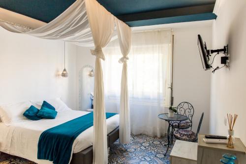 1 dormitorio con cama con dosel, sábanas azules y mesa en Mille una Notte, en Vasto