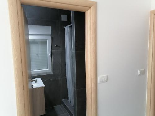 a bathroom with a shower and a sink and a mirror at Holiday Park Mimoza in Bašanija