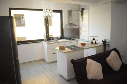 a kitchen with a couch and a stove top oven at Apartment By The Lake with a View in Mamaia