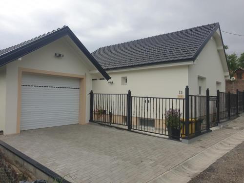 a house with a gate and a garage at Apartmani Kruna in Vrdnik