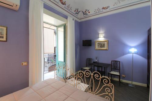 a bedroom with purple walls and a bed and a window at THE PALACE B&B and Apartments in Santo Stefano di Camastra