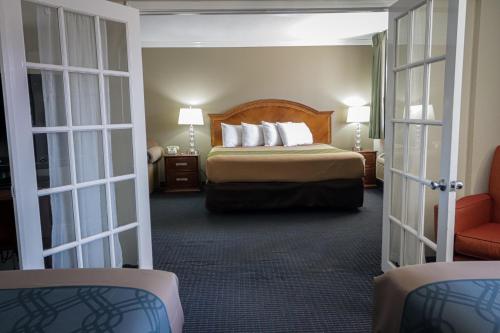 a hotel room with a bed and two sliding doors at University Inn & Suites in San Antonio