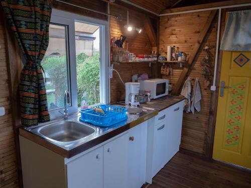 a small kitchen with a sink and a window at La Roulotte De Tina in Le Moule
