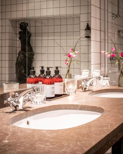 a bathroom counter with two sinks and two bottles of alcohol at Victory Hotel in Stockholm