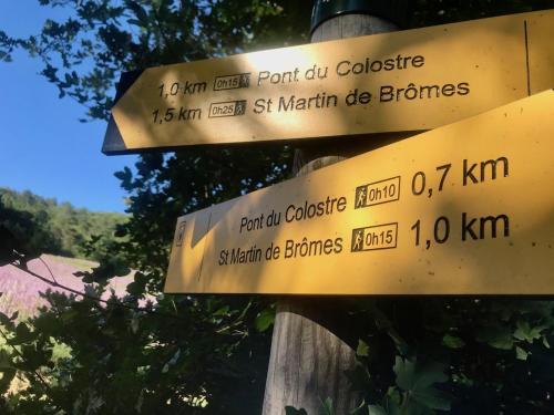 a sign on a wooden pole with signs on it at Le colostre T2 in Saint-Martin-de-Brômes
