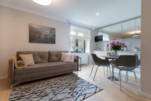 uma sala de estar e cozinha com um sofá e uma mesa em Altara Apartamenty Centrum - Free Parking em Zakopane