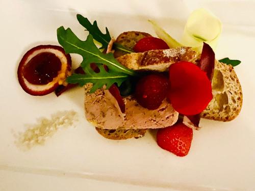 a white plate with a sandwich and strawberries on it at Le Cheval Blanc in Jargeau