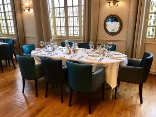 a dining room with a table with wine glasses on it at Le Cheval Blanc in Jargeau