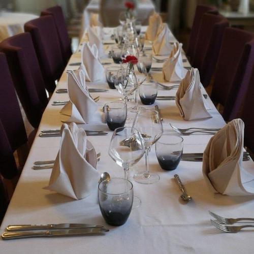 a long table set with wine glasses and napkins at Le Cheval Blanc in Jargeau