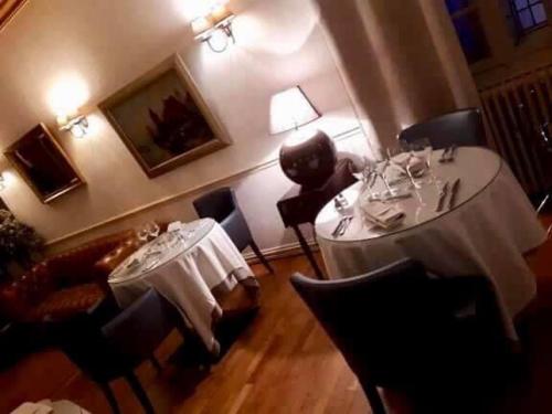 a dining room with two tables and chairs and a tableablish at Le Cheval Blanc in Jargeau