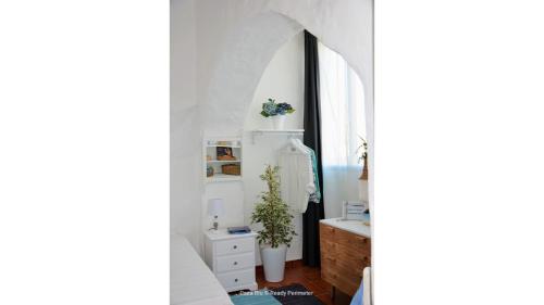 a bedroom with white walls and a sink and a mirror at Casa Blu, Beach Boho Chic, Beach and Pool - Fast Wifi in Porches
