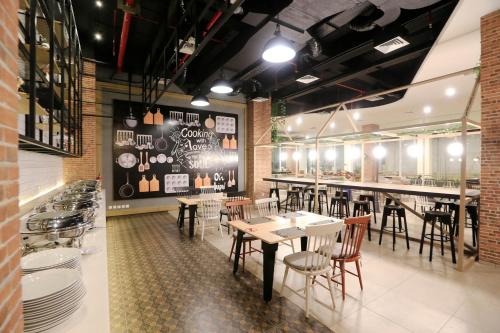 een restaurant met tafels en stoelen en een bar bij Luminor Hotel Purwokerto By WH in Purwokerto