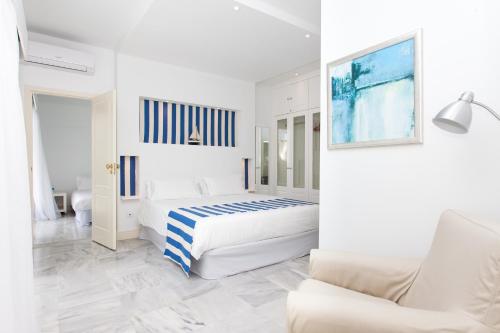 a white bedroom with a bed and a couch at Villa 34 in Corralejo