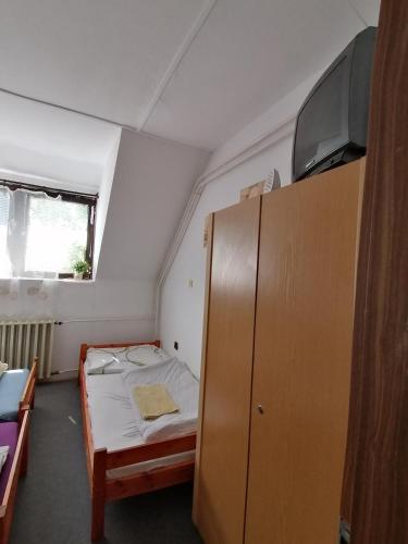 a small room with a bed and a cabinet at Malomtavi Vendégház in Tapolca