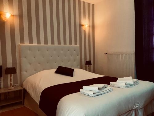 a bedroom with a bed with towels on it at Le Cheval Blanc in Jargeau