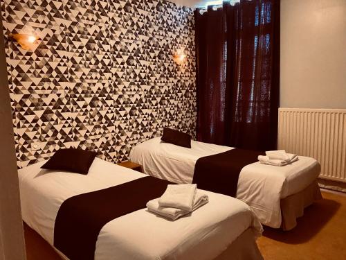 a hotel room with two beds with towels on them at Le Cheval Blanc in Jargeau