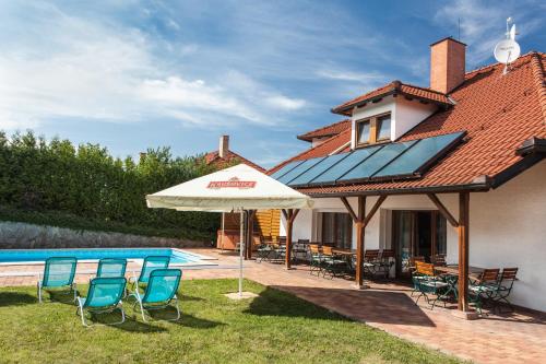 a patio with chairs and an umbrella next to a pool at Depandance Hotel u Crlíků in Tetčice