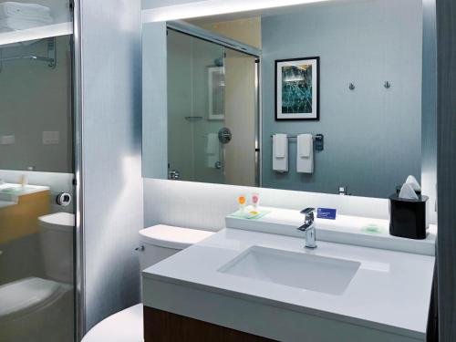 ein Badezimmer mit einem Waschbecken, einem WC und einem Spiegel in der Unterkunft Hyatt Place Houston- Northwest/Cy-Fair in Houston