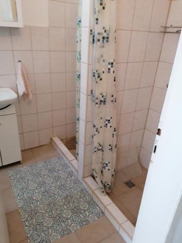 a shower with a glass door in a bathroom at Malomtavi Vendégház in Tapolca
