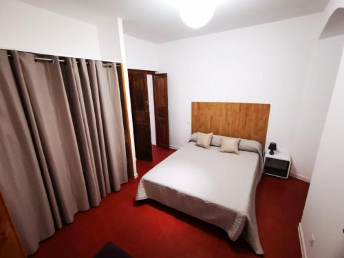 een slaapkamer met een wit bed en bruine gordijnen bij Casa Padulella (4 appartements) in Moriani Plage