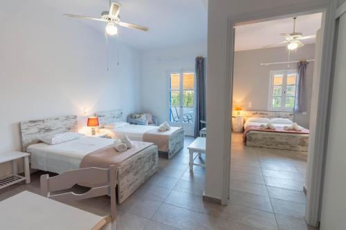 a bedroom with two beds and a living room at Meltemi Hotel Kythnos in Loutra