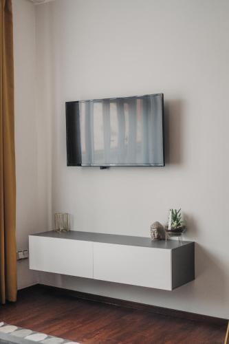 sala de estar con TV en una pared blanca en Cozy studio, 400m from the square, en Plzeň