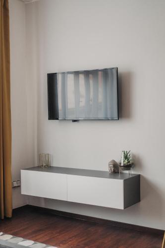 a living room with a tv on a white wall at CityBeat Apartments, 400m from the square in Plzeň