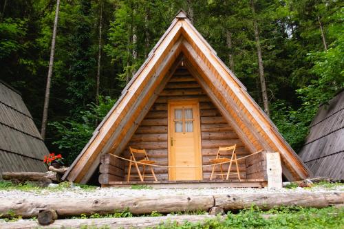 Cabaña de madera con 2 sillas y puerta en Camp ŠMICA, en Luče